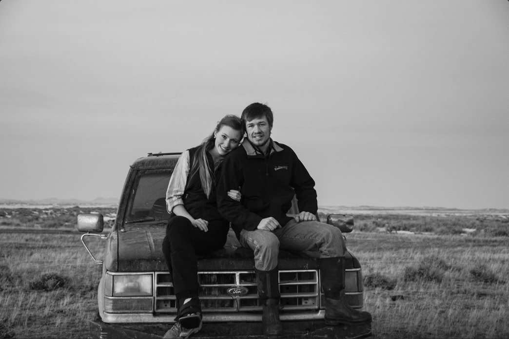 young couple posing on old ranch vehicle, central montana family cattle ranch